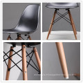 Style scandinave en gros pas cher style nordique jolie chaise en plastique salon noir PP chaise avec pieds en hêtre